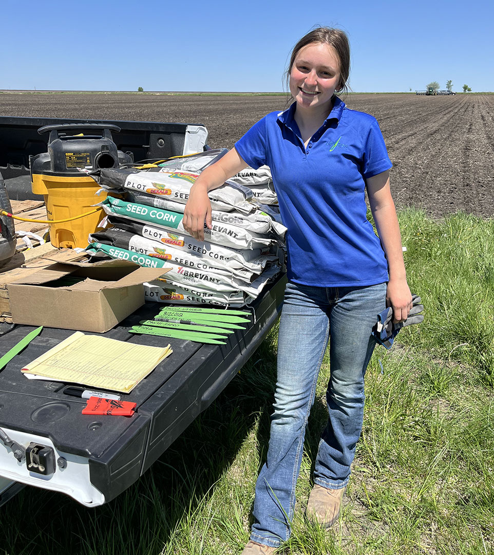 liqui-grow employee standing at back of pickup truck full of seed corn