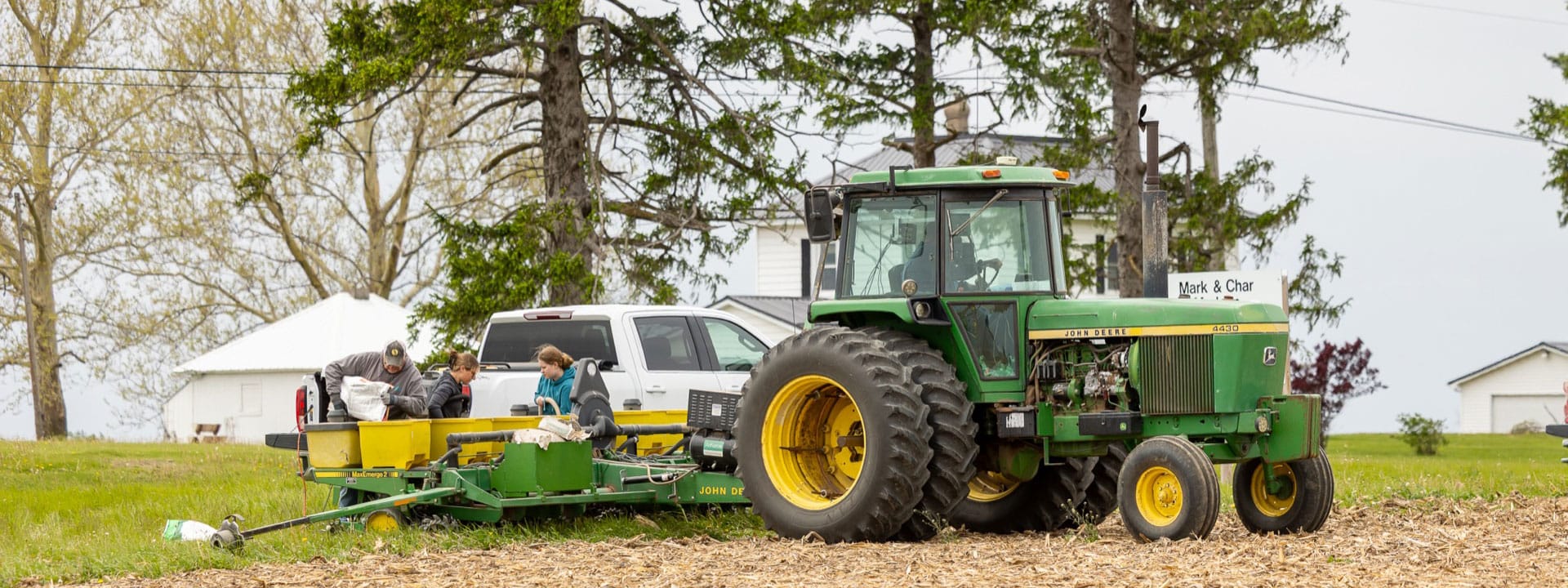 Tractor sitting patiently while Liqui-Grow employees fill bins in the trailer with seed.